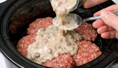 Pour cream of mushroom soup over raw hamburger patties, alongside 3 simple ingredients, into slow cooker for a budget-friendly dinner that disappears faster than anything else
