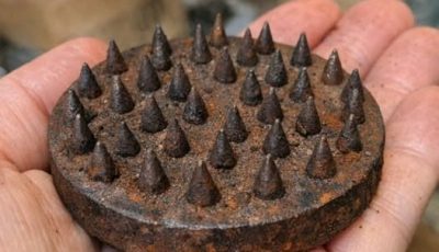 Clearing out the attic and found this heavy metal base covered in sharp spikes. It’s rusted and looks dangerous. What is this?